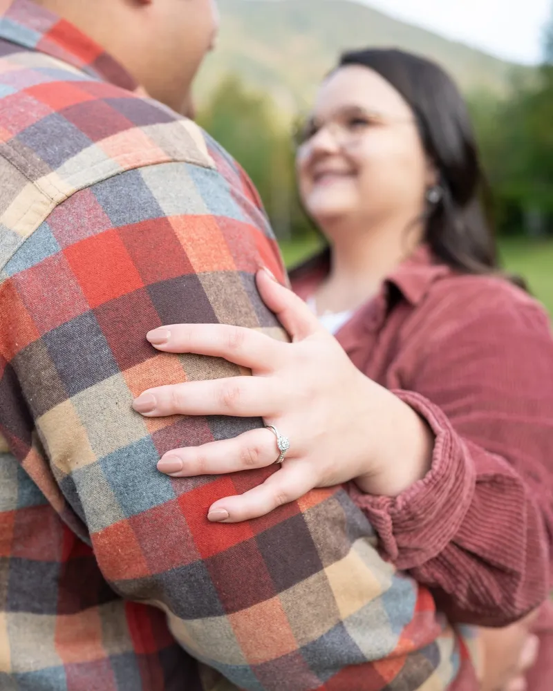 A couple in autumn flannel sharing a quiet moment during an engagement session.
